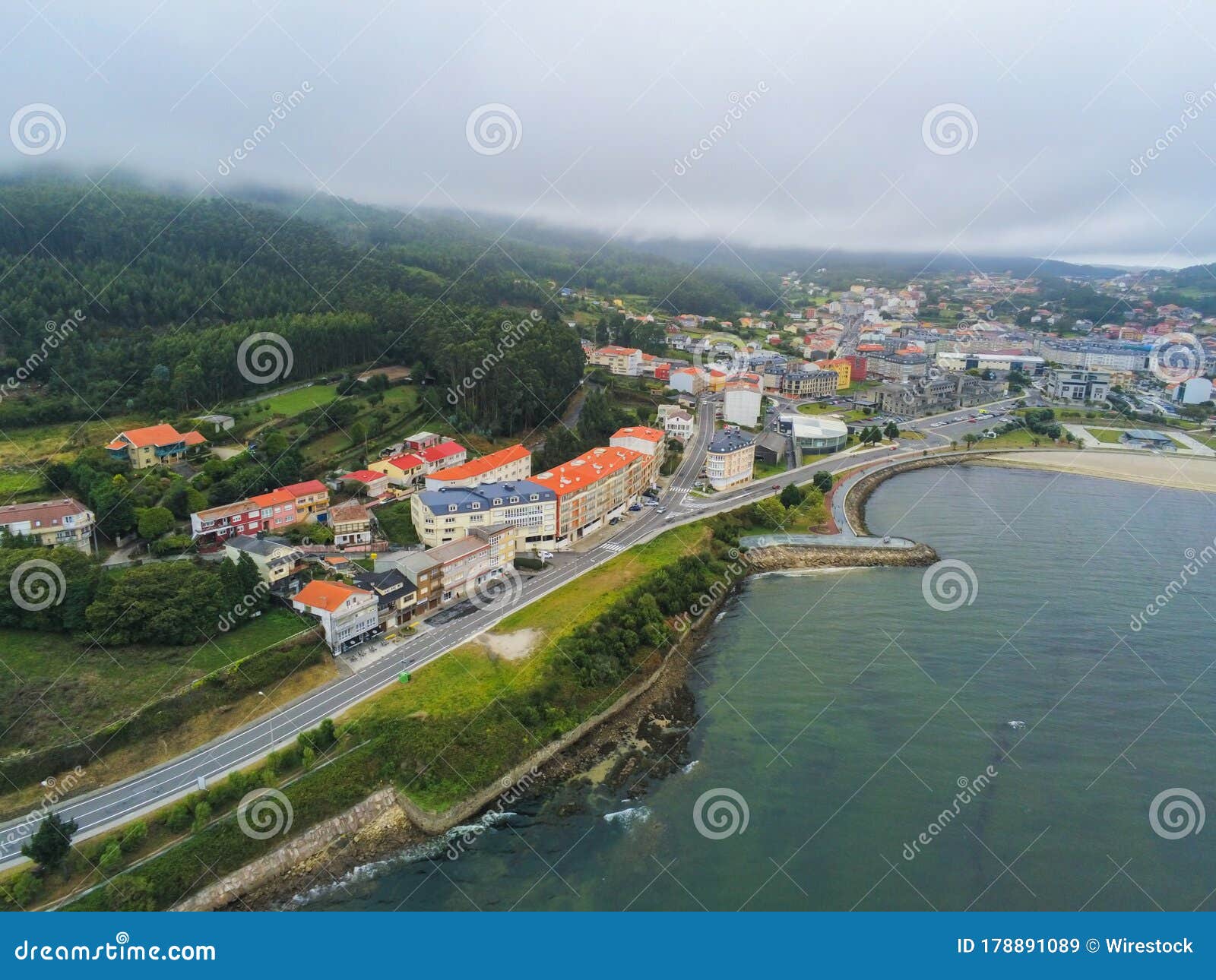 aerial shot of building near the mountain under a cloudy sky in galicia, spain