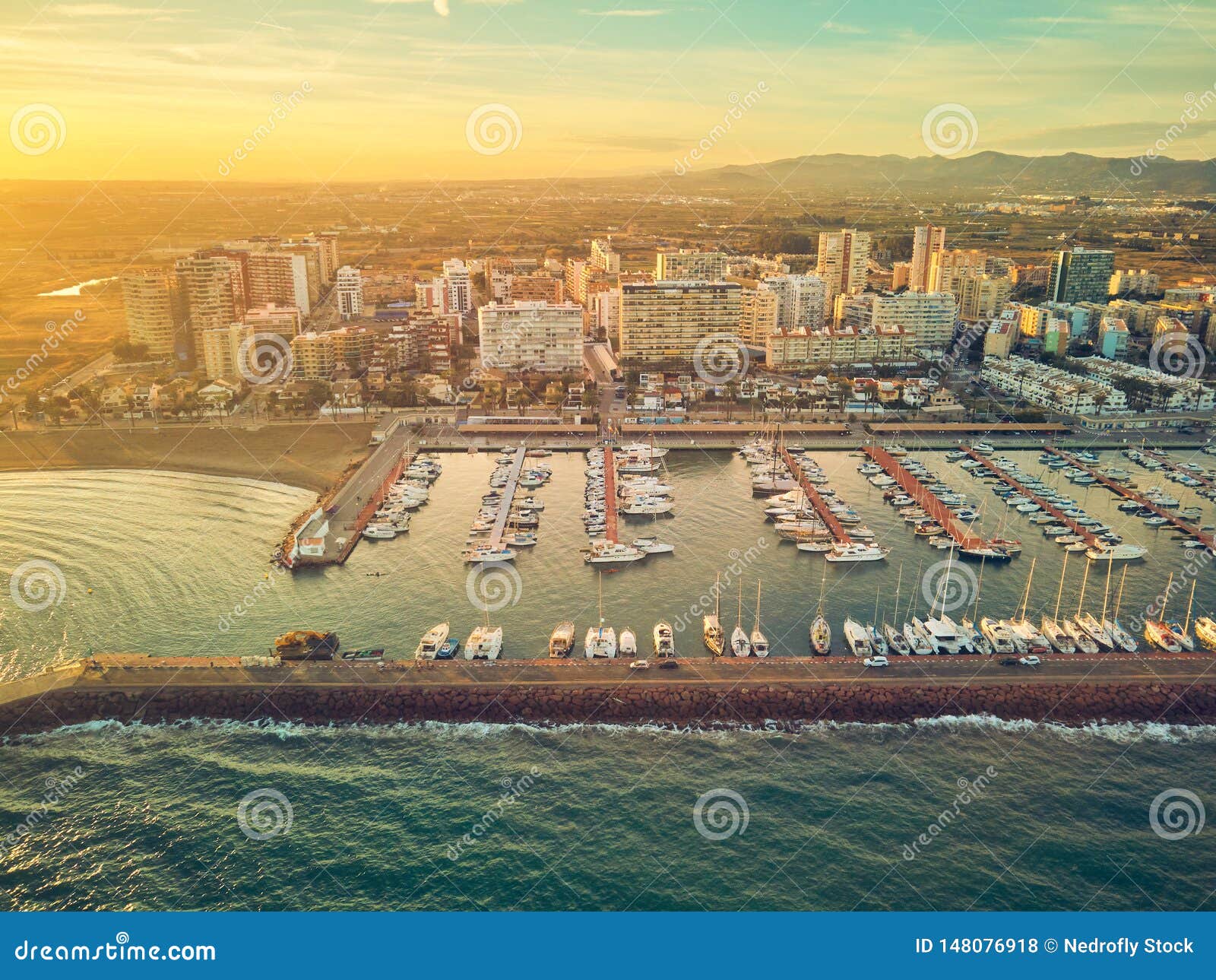 aerial sunset view of the marina of la pobla de farnals, valencia, spain. boats moored in the harbor at sunset of the