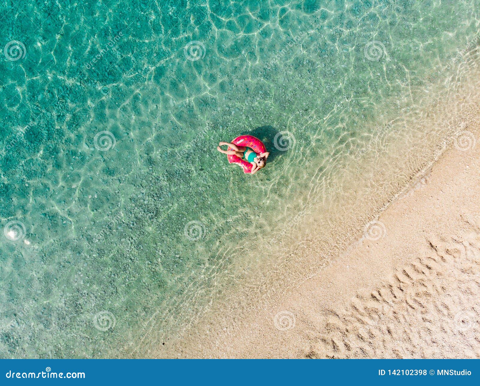 Aerial Top Down View of Cute Young Girl Floating on Toy Ring at Myrtos ...