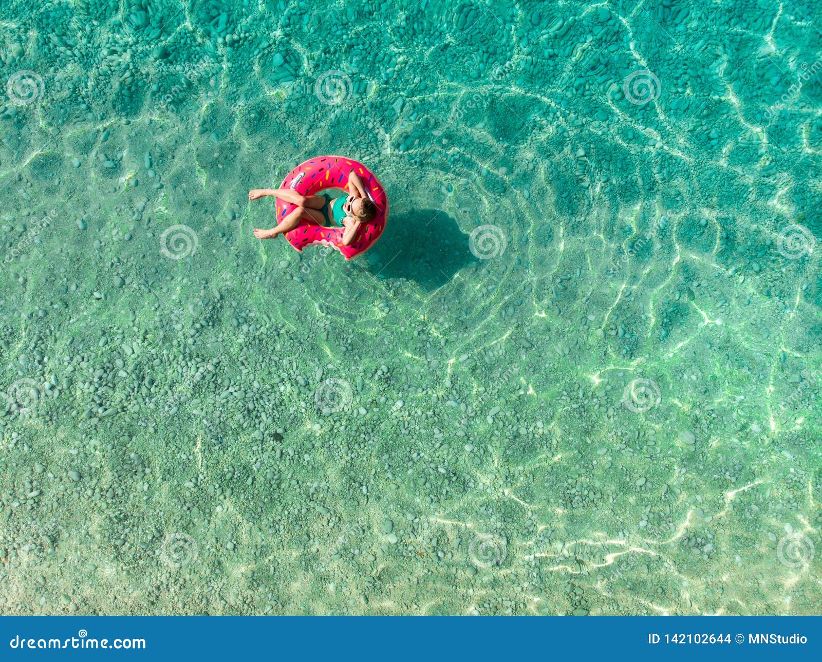 Aerial Top Down View of Cute Young Girl Floating on Toy Ring at Myrtos ...