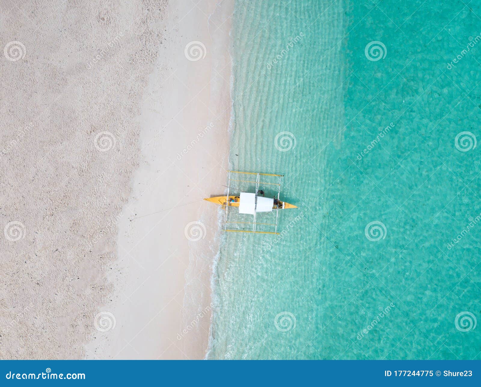 aerial top down view of white sand beach with a traditional philippine boats beached on it