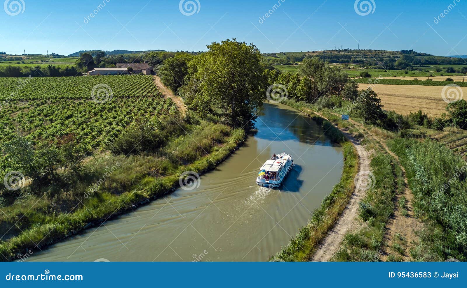 aerial top view of boat in canal du midi from above, travel by barge in southern france