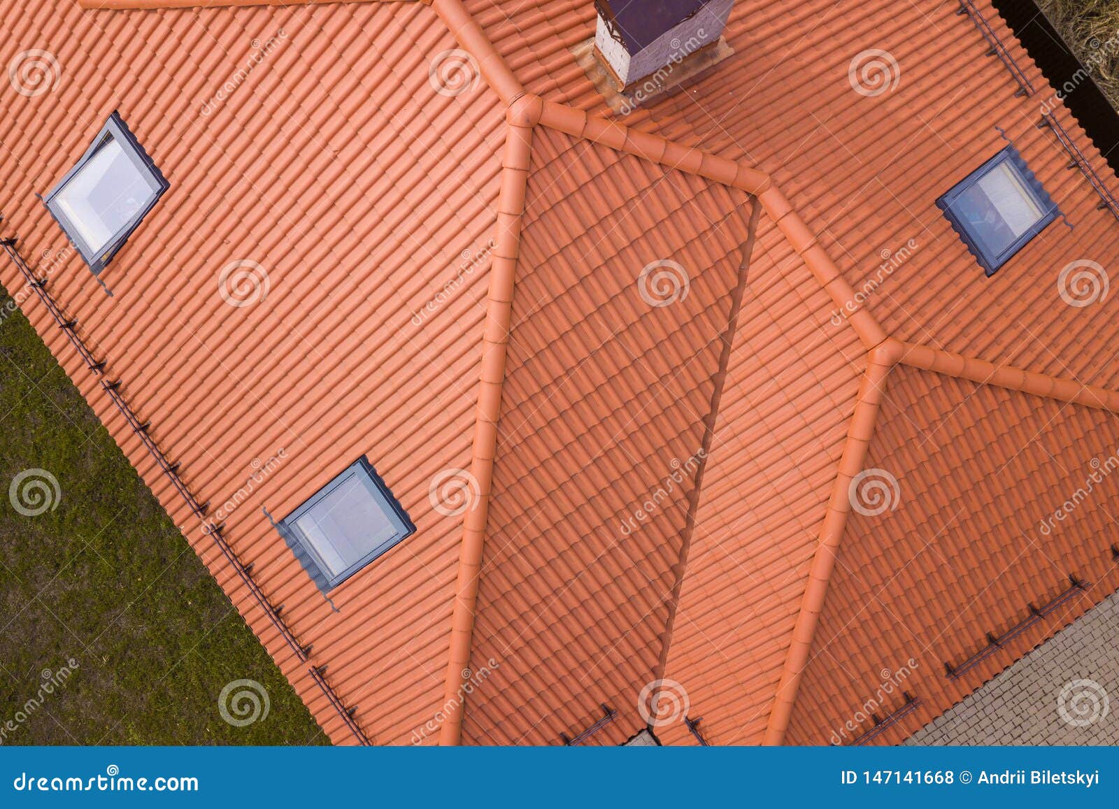 aerial top view of house metal shingle roof, brick chimneys and small plastic attic windows. roofing, repair and renovation work