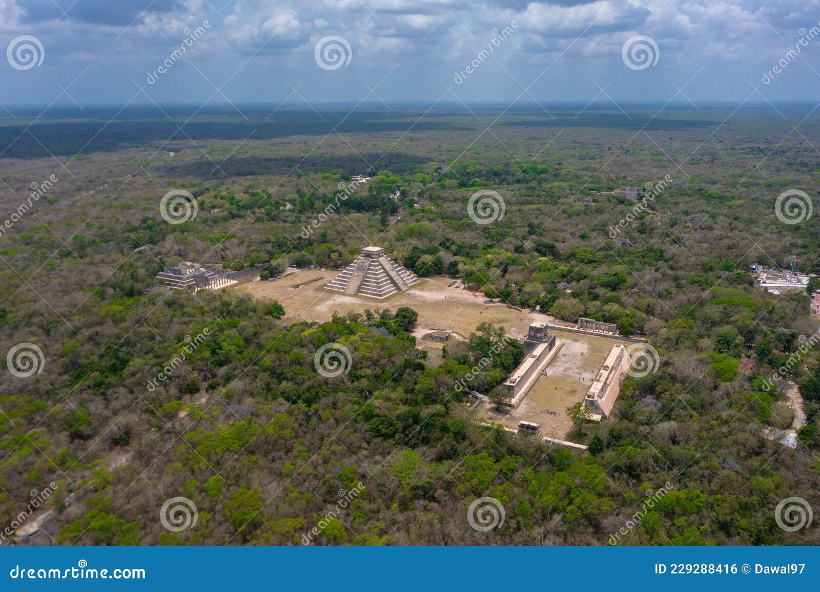 aerial view of the beautiful chicen itza and mayan pyramid in mexico surrounded with ground and greenery with ocean
