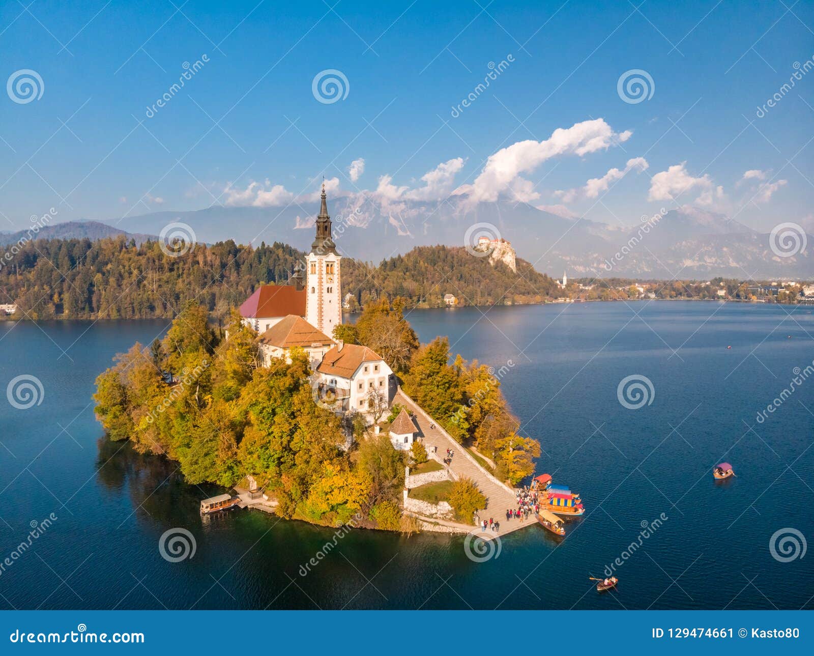 aerial view of bled island on lake bled, and bled castle and mountains in background, slovenia.