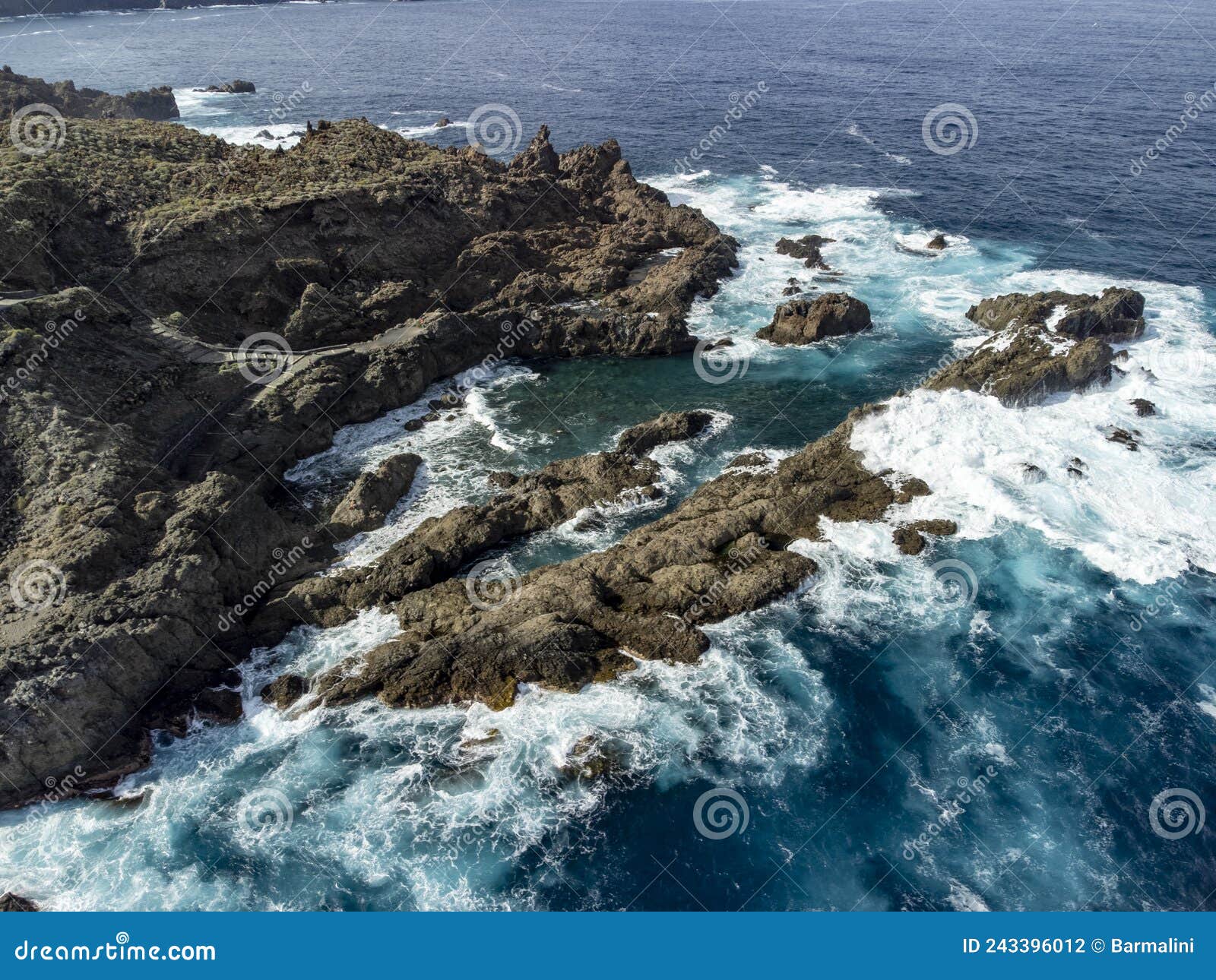 aerial view on charco del viento natural pool in black lava rocks on tenerife, canary islands, spain