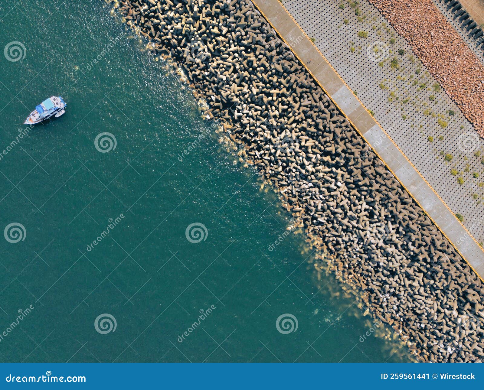 aerial view of dolos blocks on the shore near the sea with a boat in hong kong