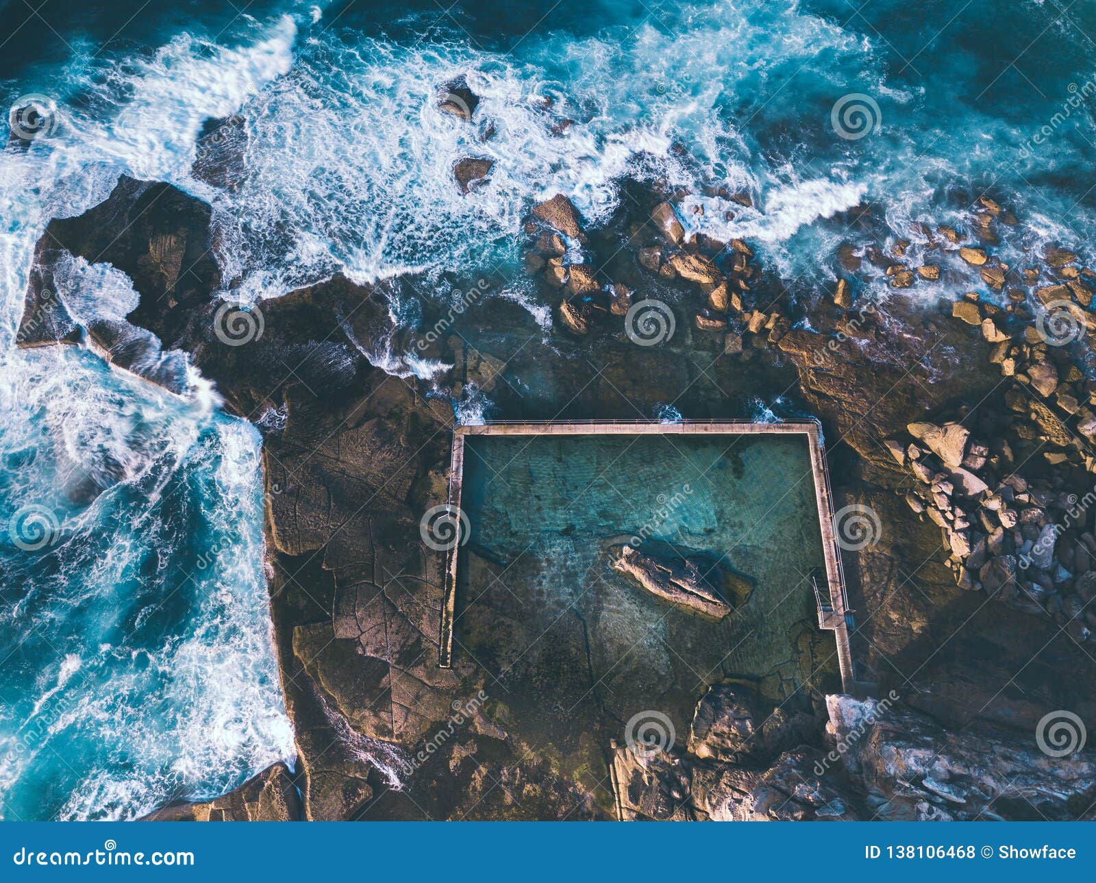 aerial view of waves around curl curl rock pool