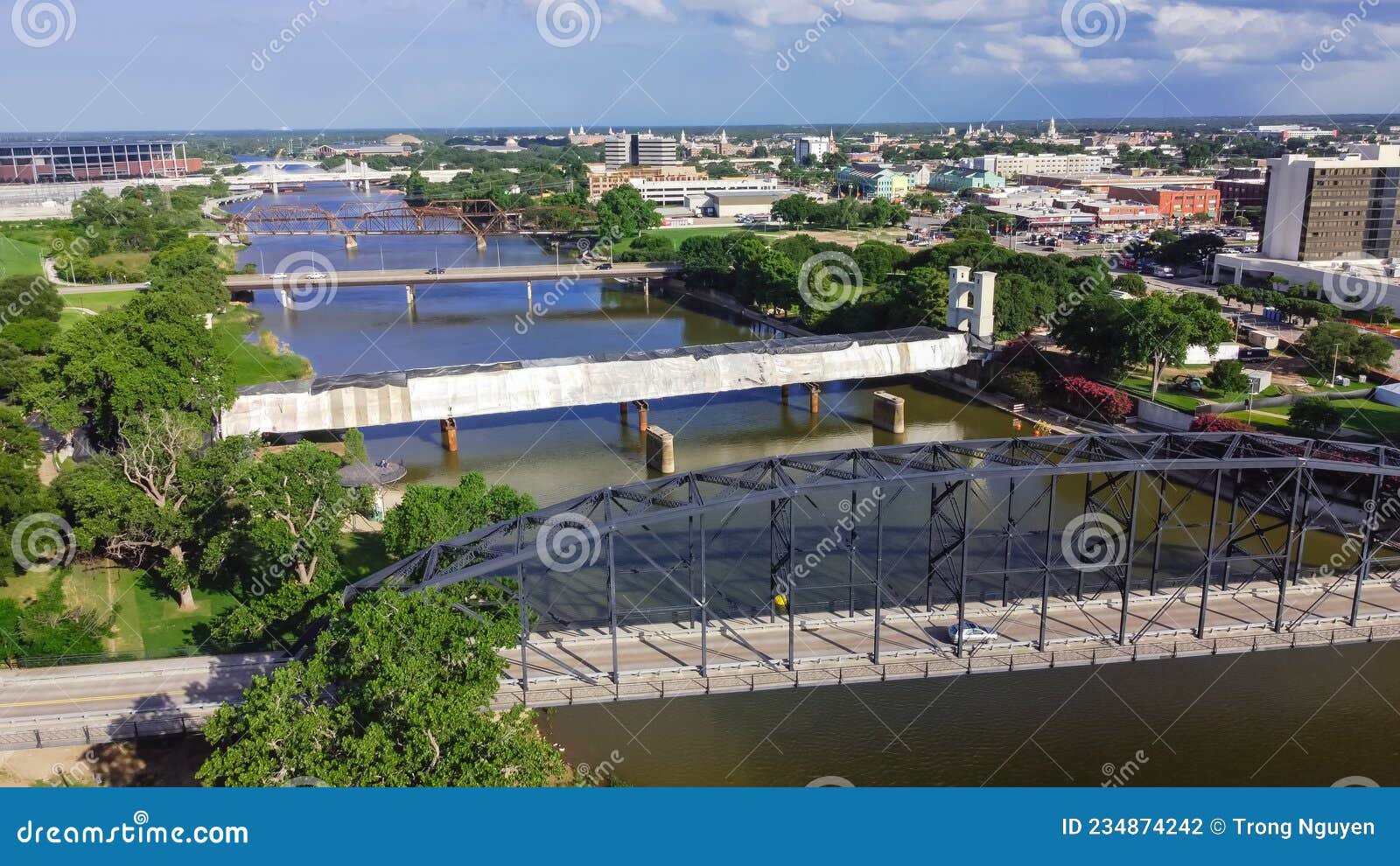 top view four bridges including vehicular, railway and suspension bridge cross the brazos river in downtown waco, texas
