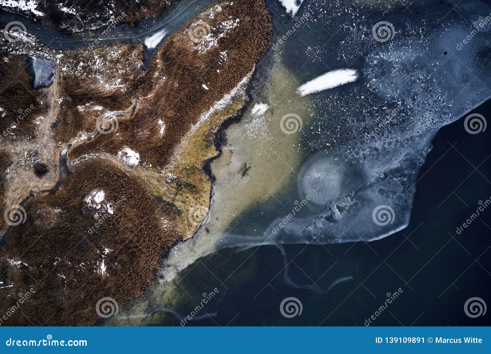 Aerial View of a Frozen Lake, Water, Brown Grass and Mud Forming ...