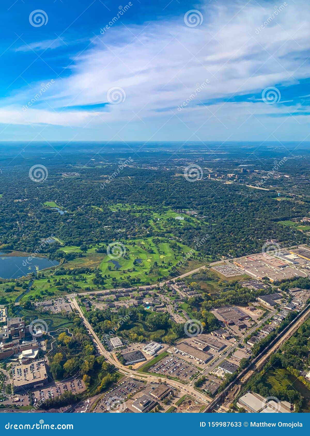 aerial view of golf courses in a densely forested urban development