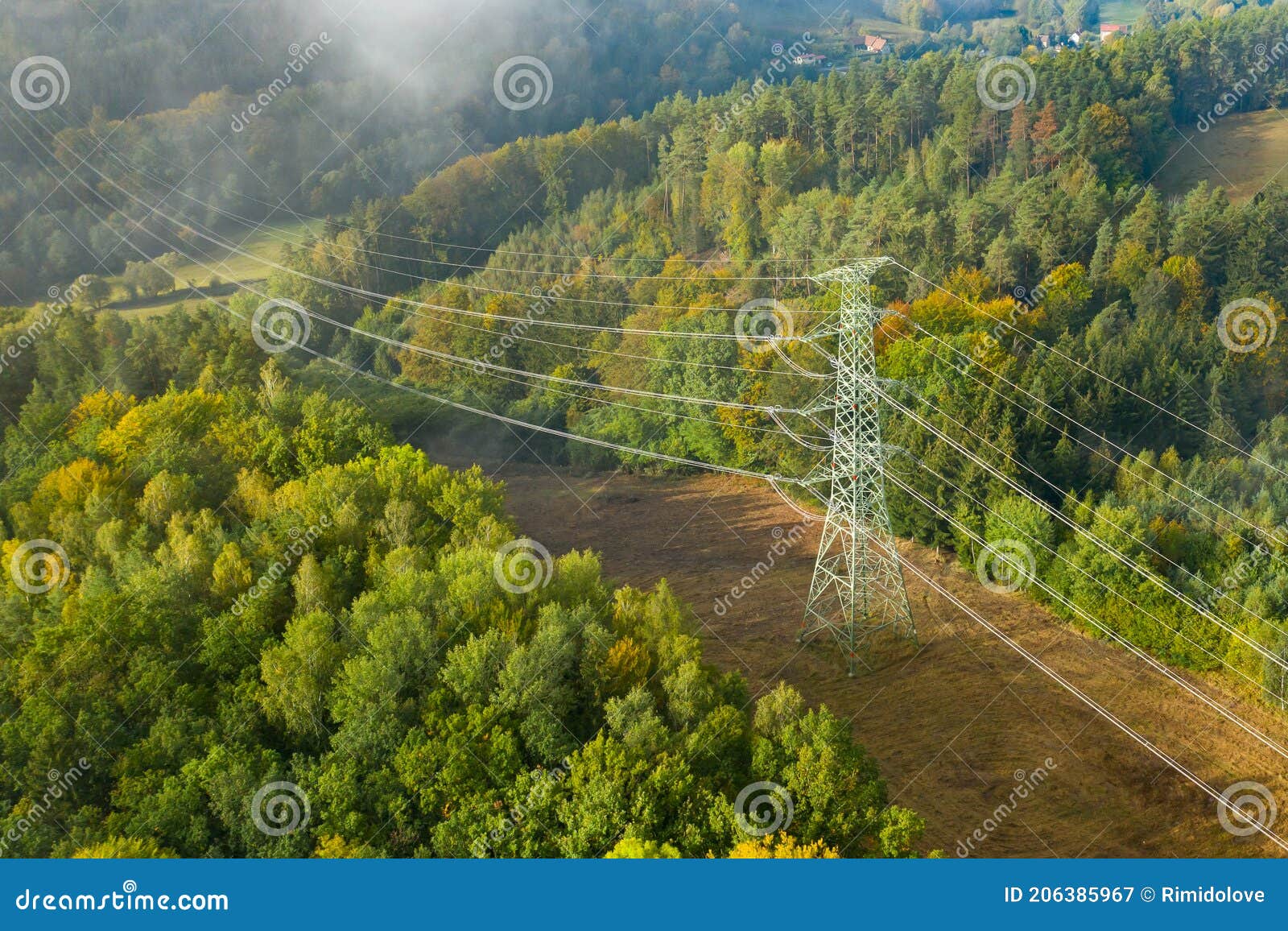 aerial view of the high voltage power lines and high voltage electric transmission on the terrain surrounded by trees at