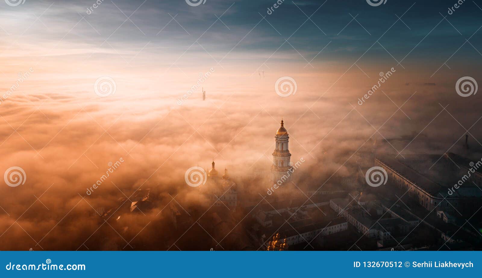 aerial view of kiev pechersk lavra at dawn and the city covered with thick fog in the background.