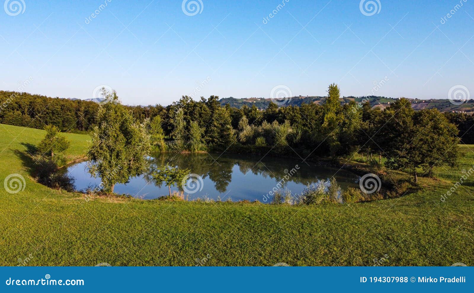 aerial view of a little lake and trees surrounding, in italian appennini hills