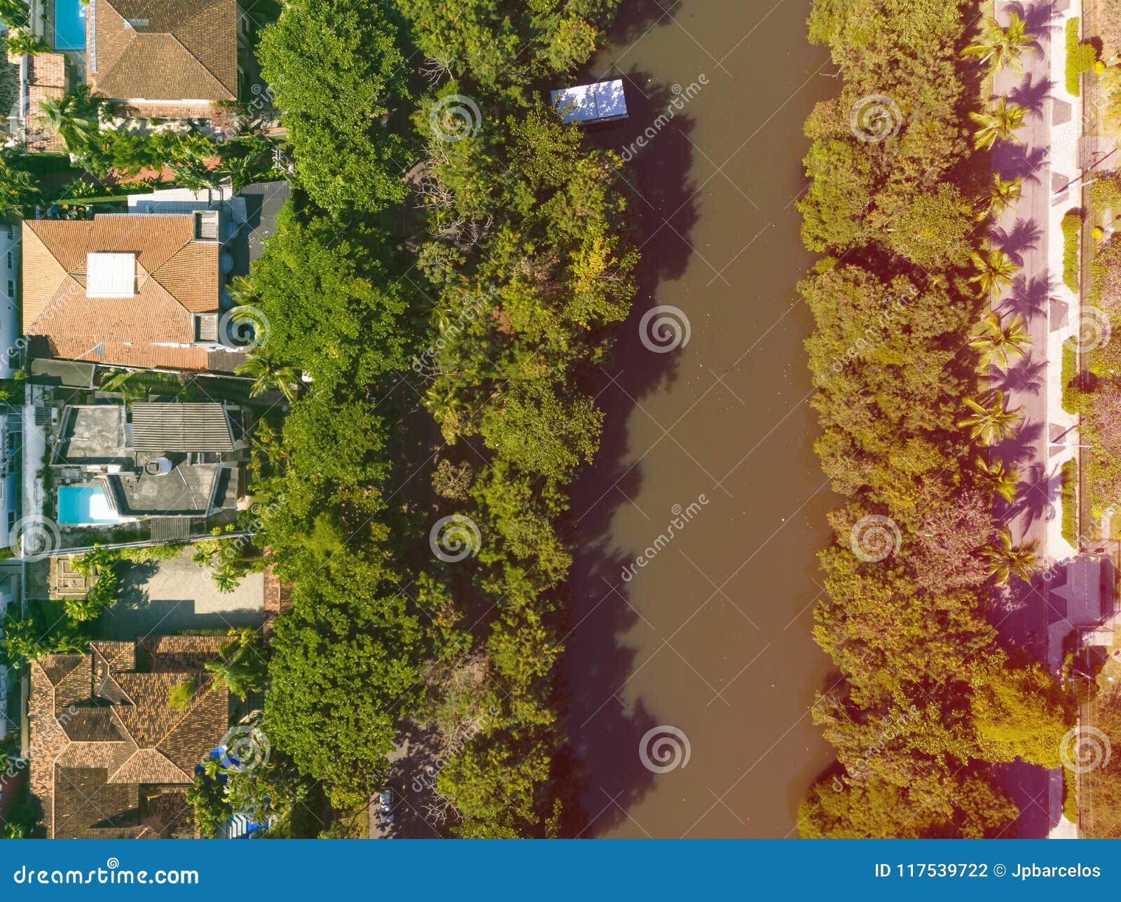 Aerial view o Marapendi canal in Barra da tijuca on a summer day. Green vegetation can be seen on both sides, as well as houses.