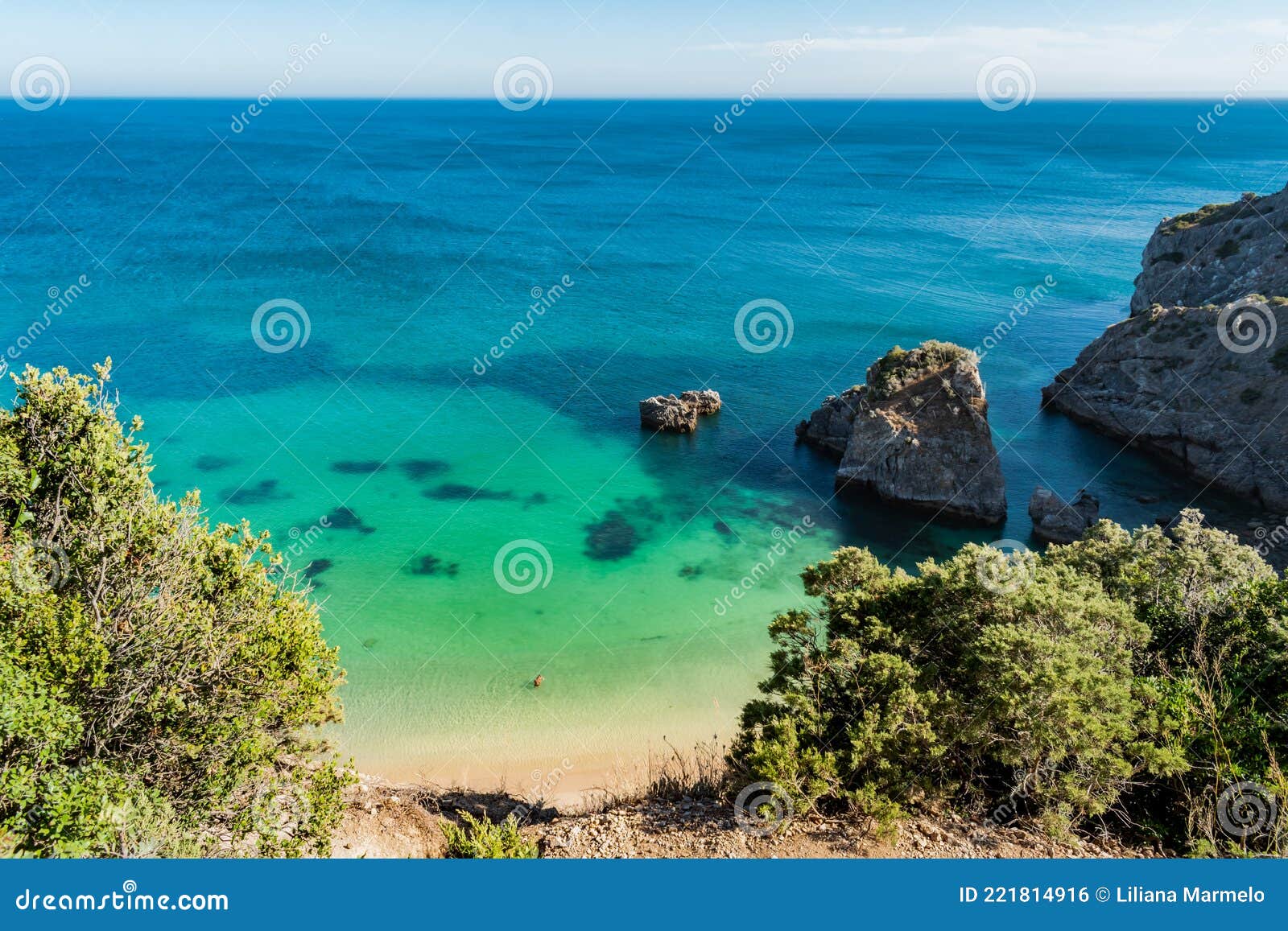 cliff at ribeiro do cavalo beach, with clear water and rocks, sesimbra portugal