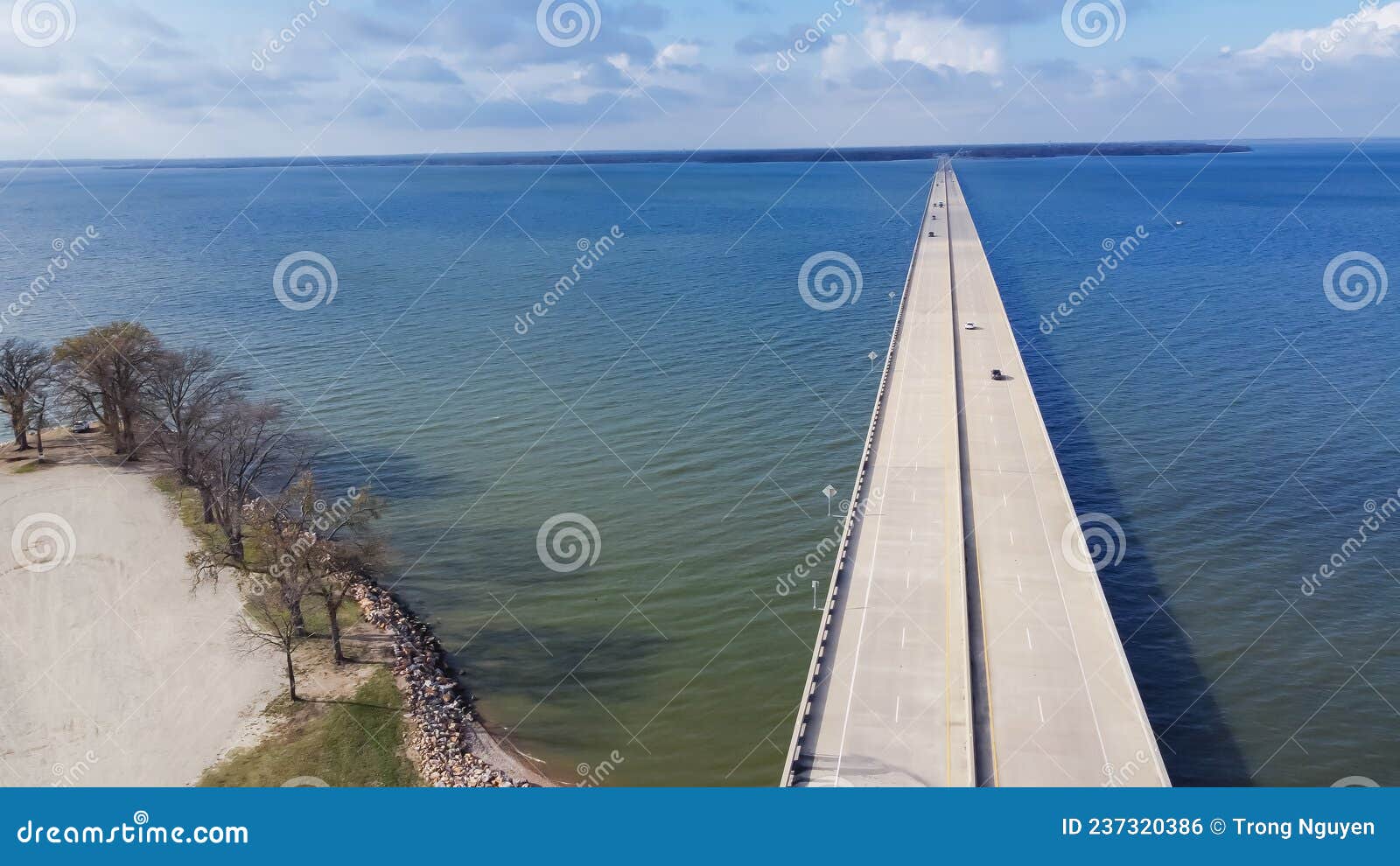 Aerial View Rock Wall Shoreline Lakefront and Two Mile Bridge Over Lake