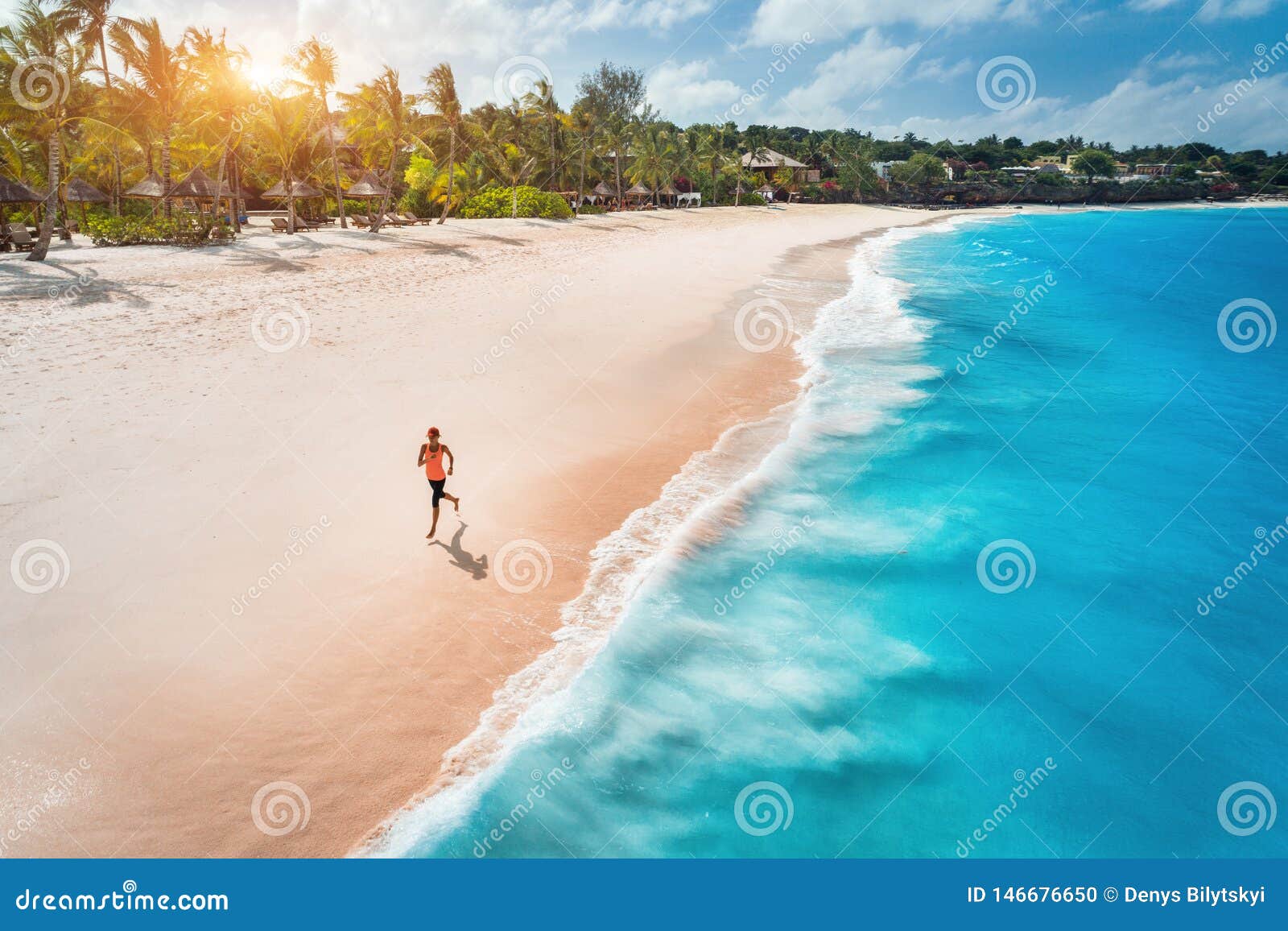 aerial view of the running young woman on the sandy beach