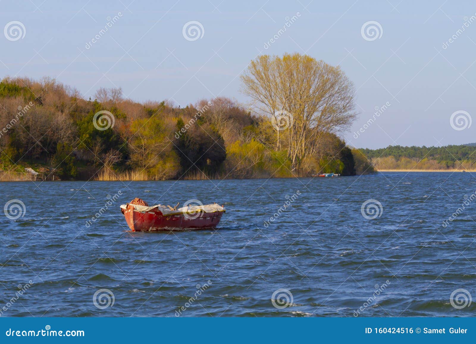 a spectacular view of the tranquil waters of lake durusu lake terkos at sunrise with several abandoned boats in the foreground.