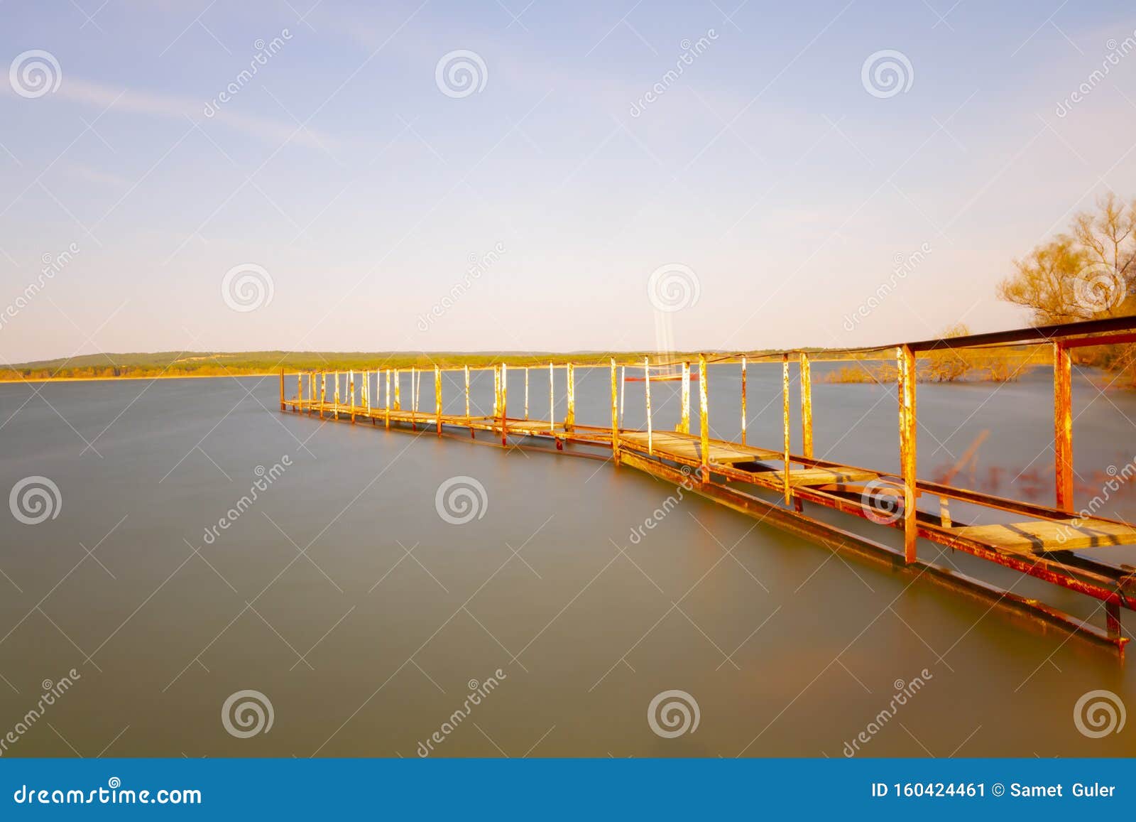 a spectacular view of the tranquil waters of lake durusu lake terkos at sunrise with several abandoned boats in the foreground.