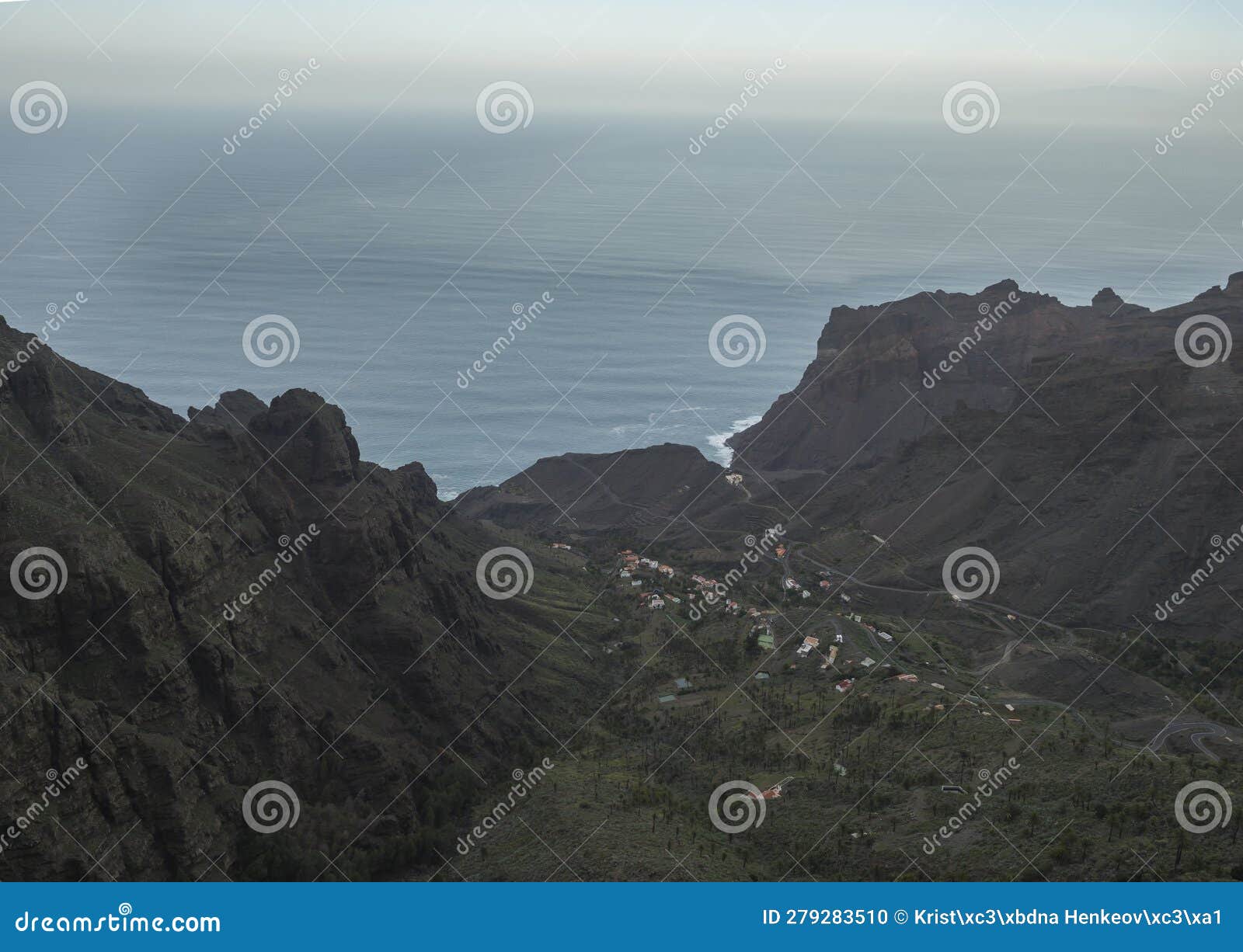 aerial view towards the valley of village taguluche with small houses, sharp cliffs and atlantic ocean, viewpoint