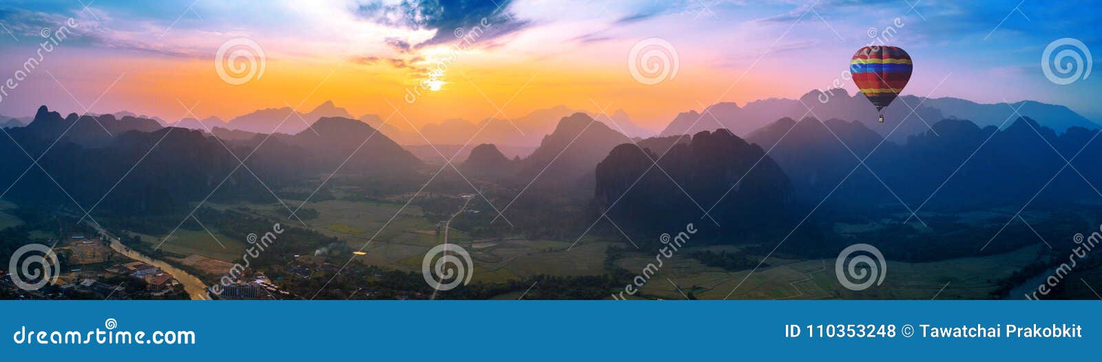 Aerial view of Vang vieng with mountains and balloon at sunset.