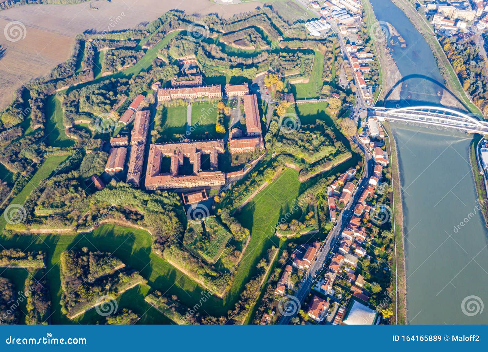 aerial view of walls and bastions of modern six-star hexagon d fort cittadella of alessandria on winding river tanaro