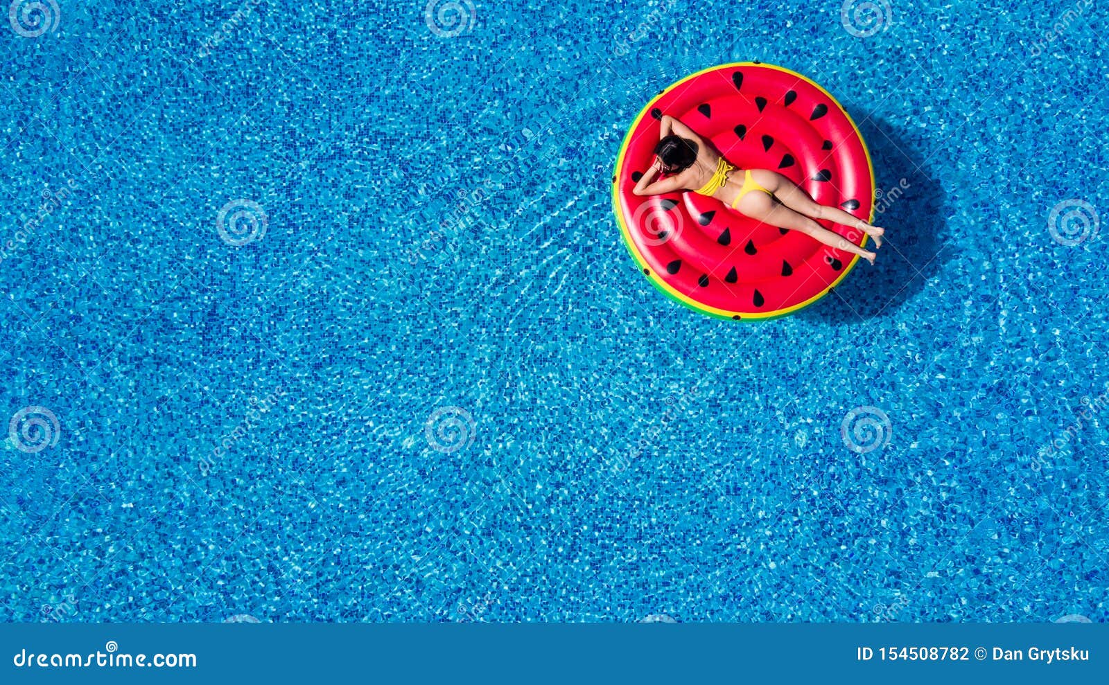 Aerial View Of Woman In Bikini Lying On A Floating Mattress In Swimming Pool In Swimming Pool