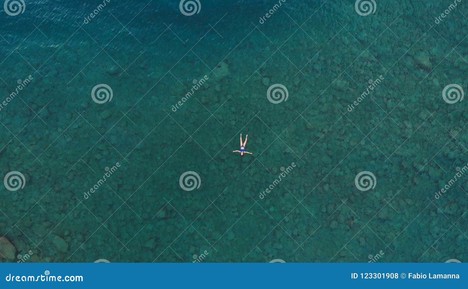 AERIAL: Woman Floating on Blue Water Surface, Swimming in Transparent ...