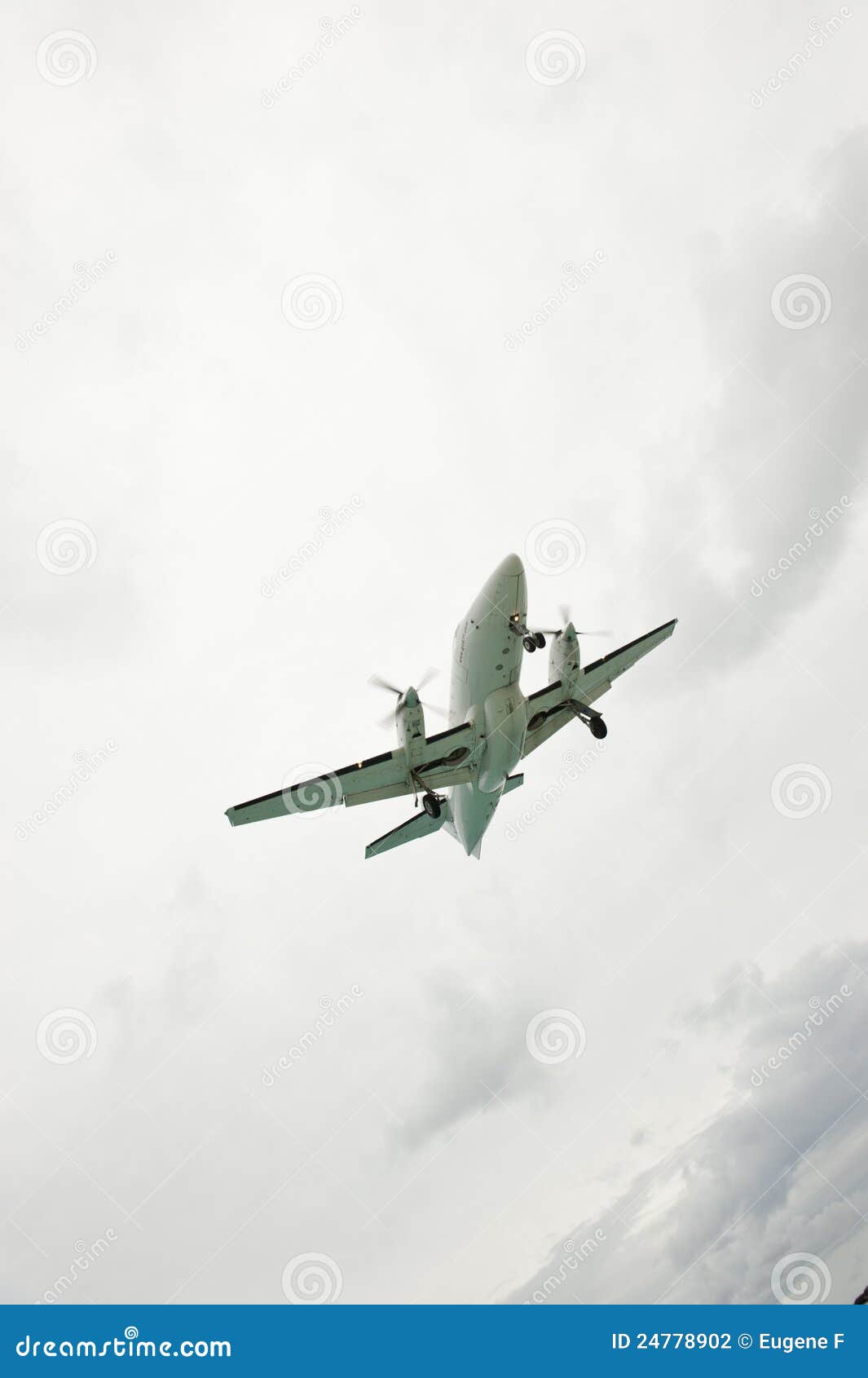 Aeroplano fatto pendere nuvoloso. Sparato catturato dalla terra della parte inferiore di un volo dell'aeroplano su un angolo in un cielo nuvoloso.