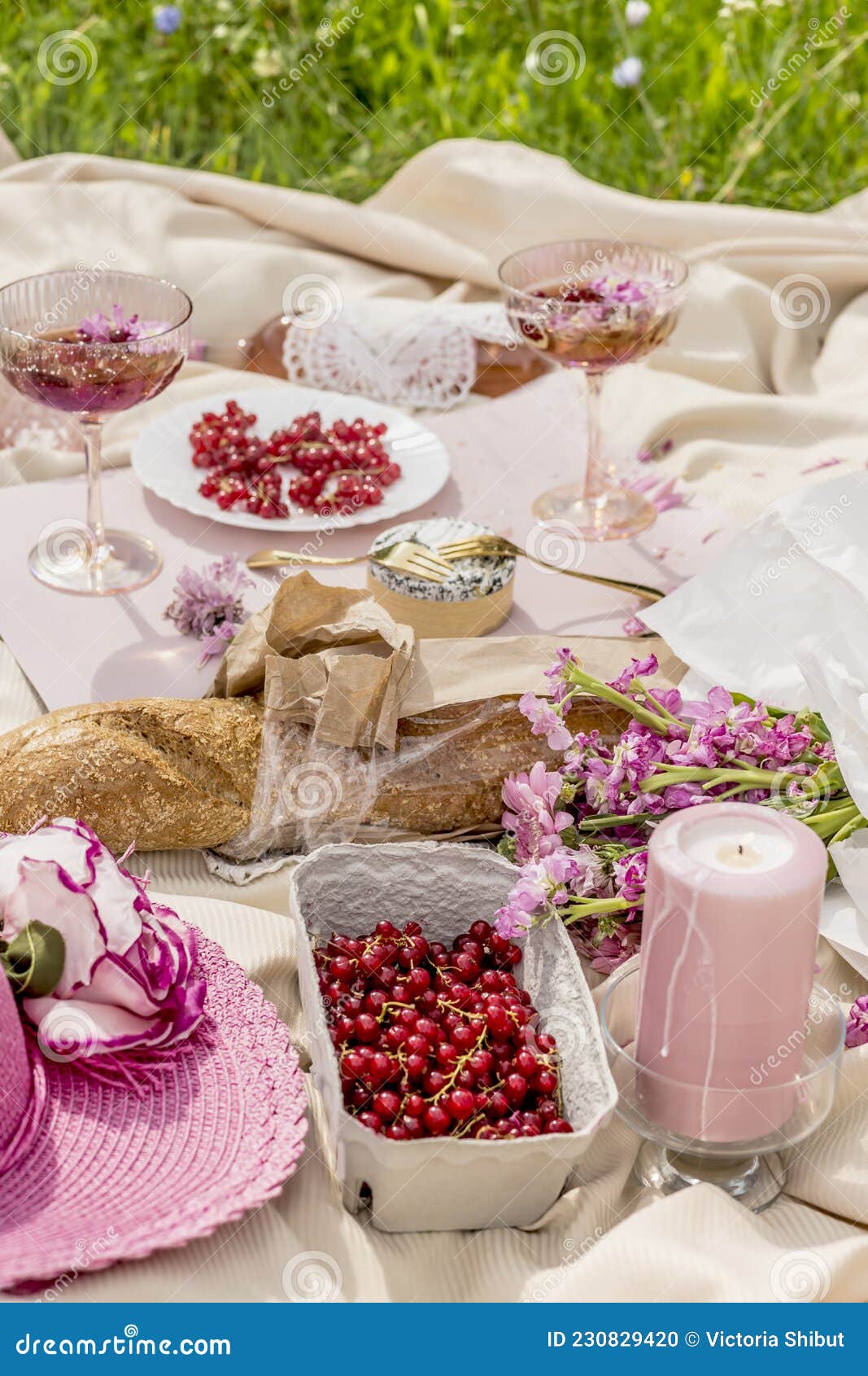 Aesthetic picnic outdoors with wine glasses bread berries and flowers.  Rustic picnic with neutral tones colours. Stock Photo by  ©lamapacas.gmail.com 378420028