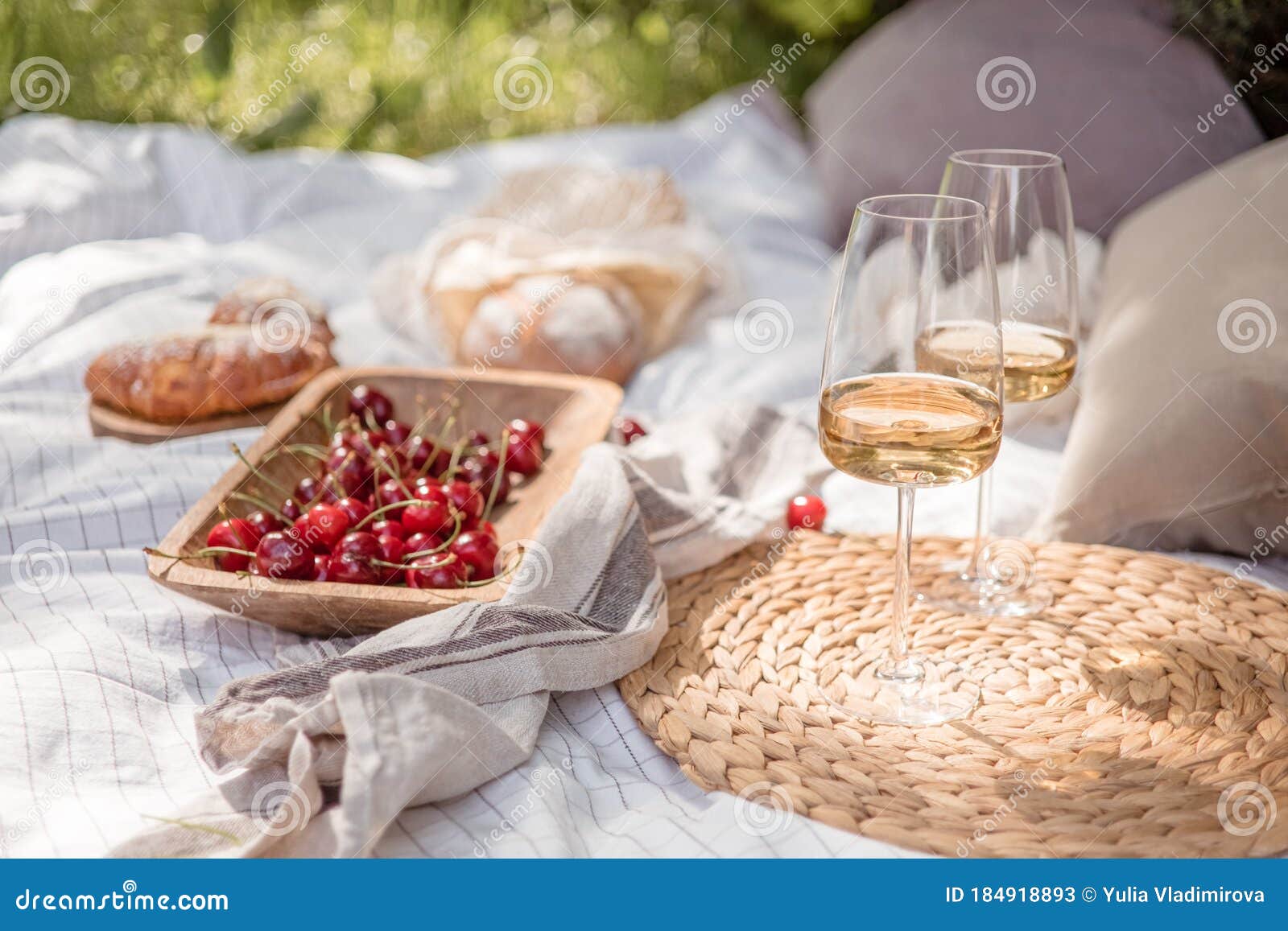 Aesthetic picnic outdoors with wine glasses bread berries and flowers.  Rustic picnic with neutral tones colours. Stock Photo by  ©lamapacas.gmail.com 378791178