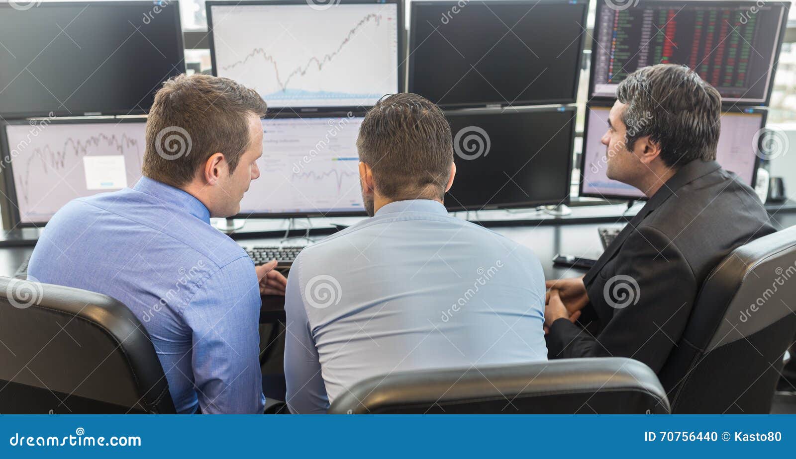 Affärsfolk som ser datorskärmar. Affärsmän som ser data på åtskilliga datorskärmar i företags kontor Affärsfolk som direktanslutet handlar Affär, egenföretagande och lagarbetsbegrepp