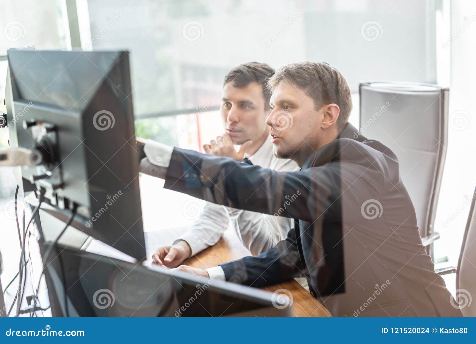 Affärslag som analyserar data på affärsmötet. Bild av två fundersamma affärsmän som ser data på datorskärmar som löser affärsfrågan på affärsmötet i moderkontor