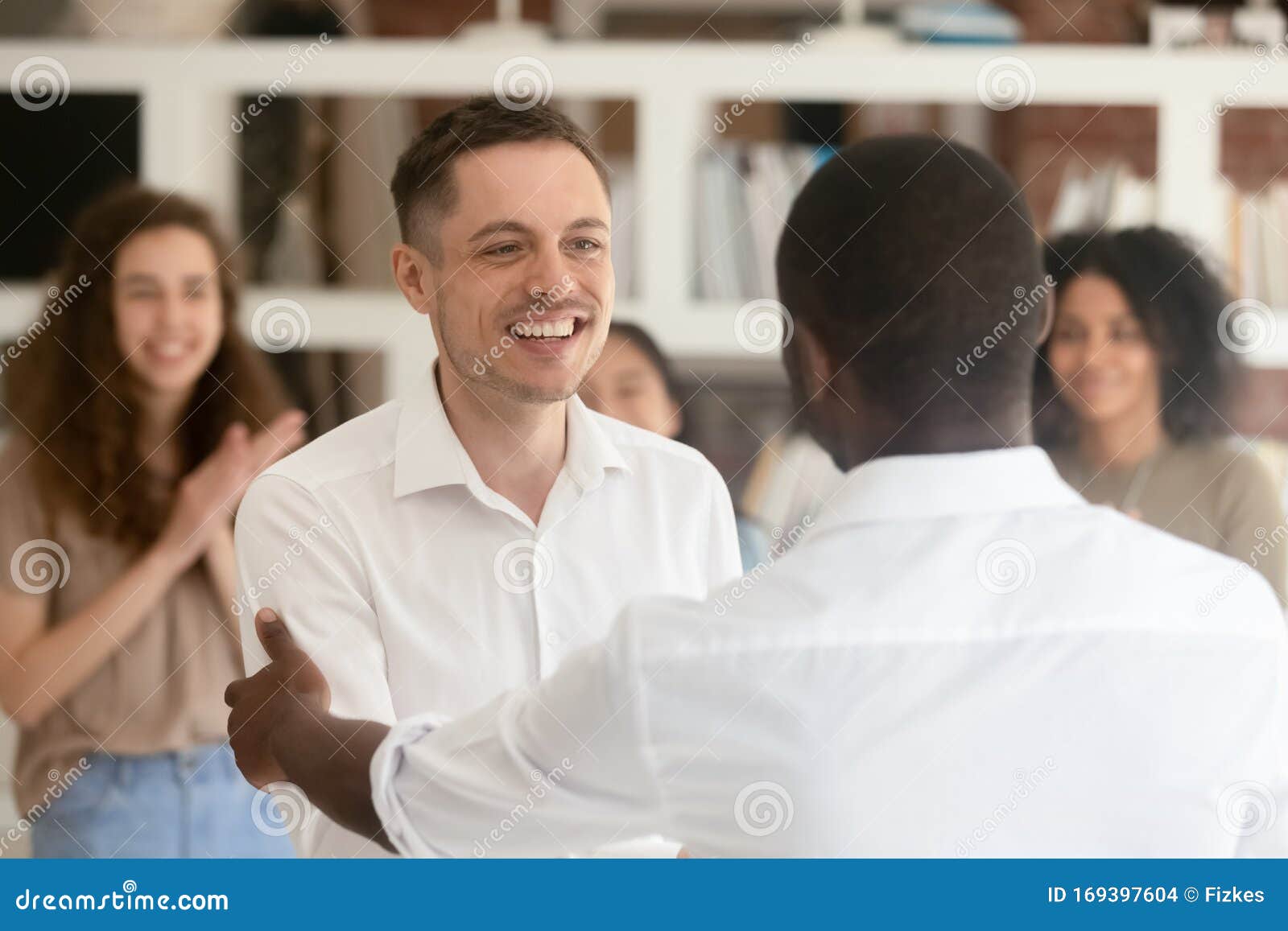 black boss handshake congratulating excited caucasian employee