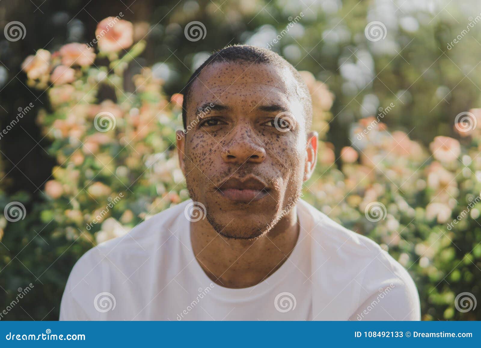african american man with freckles outdoors looking serious