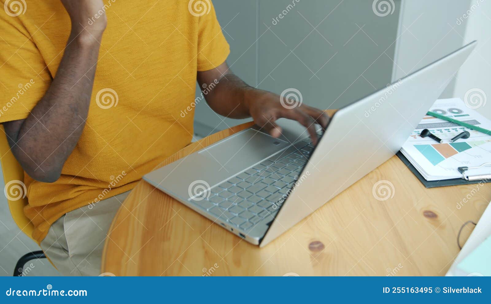 African American Man Freelancer Working with Laptop Typing and Talking