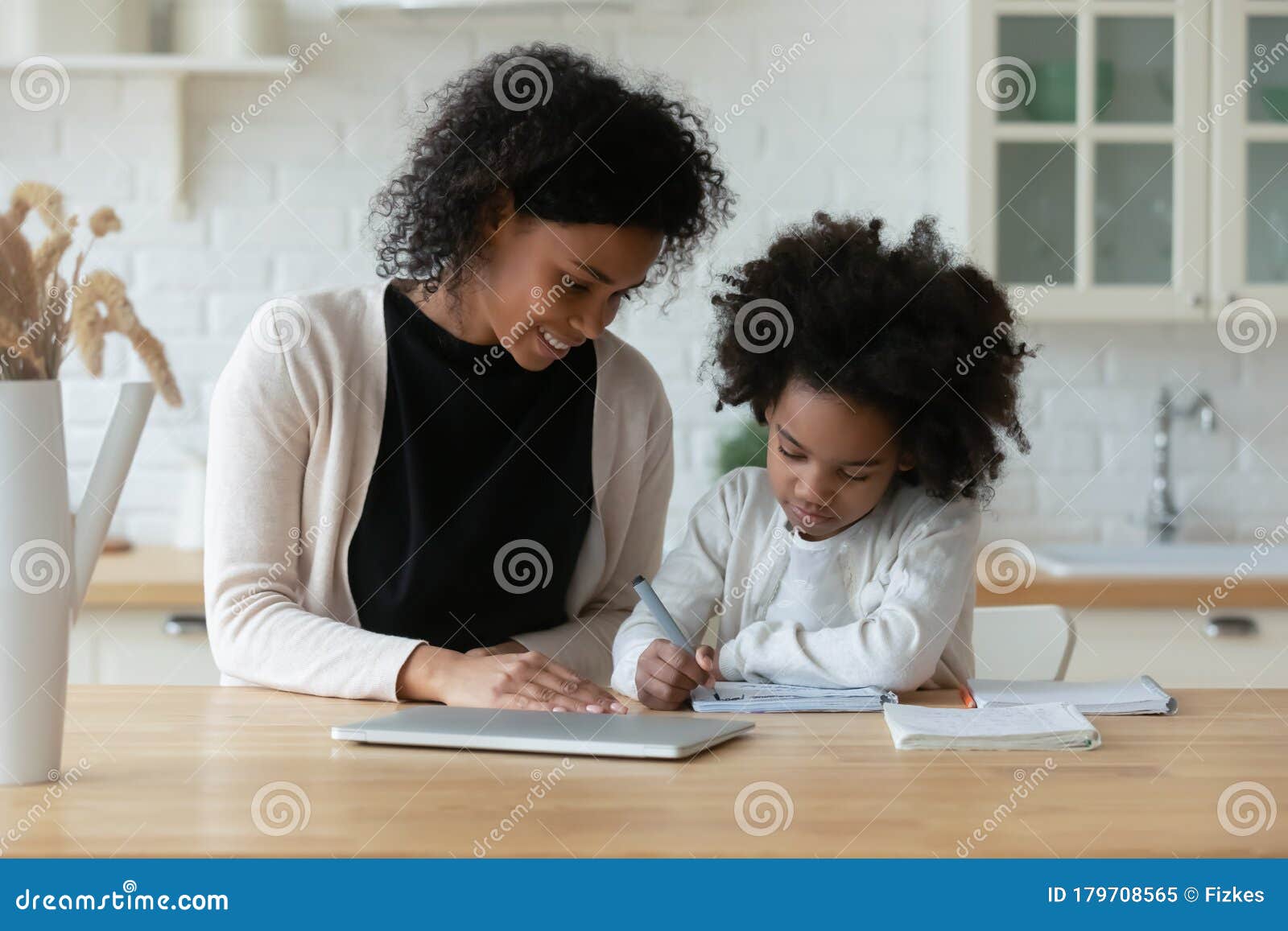 african american mom and little daughter study online