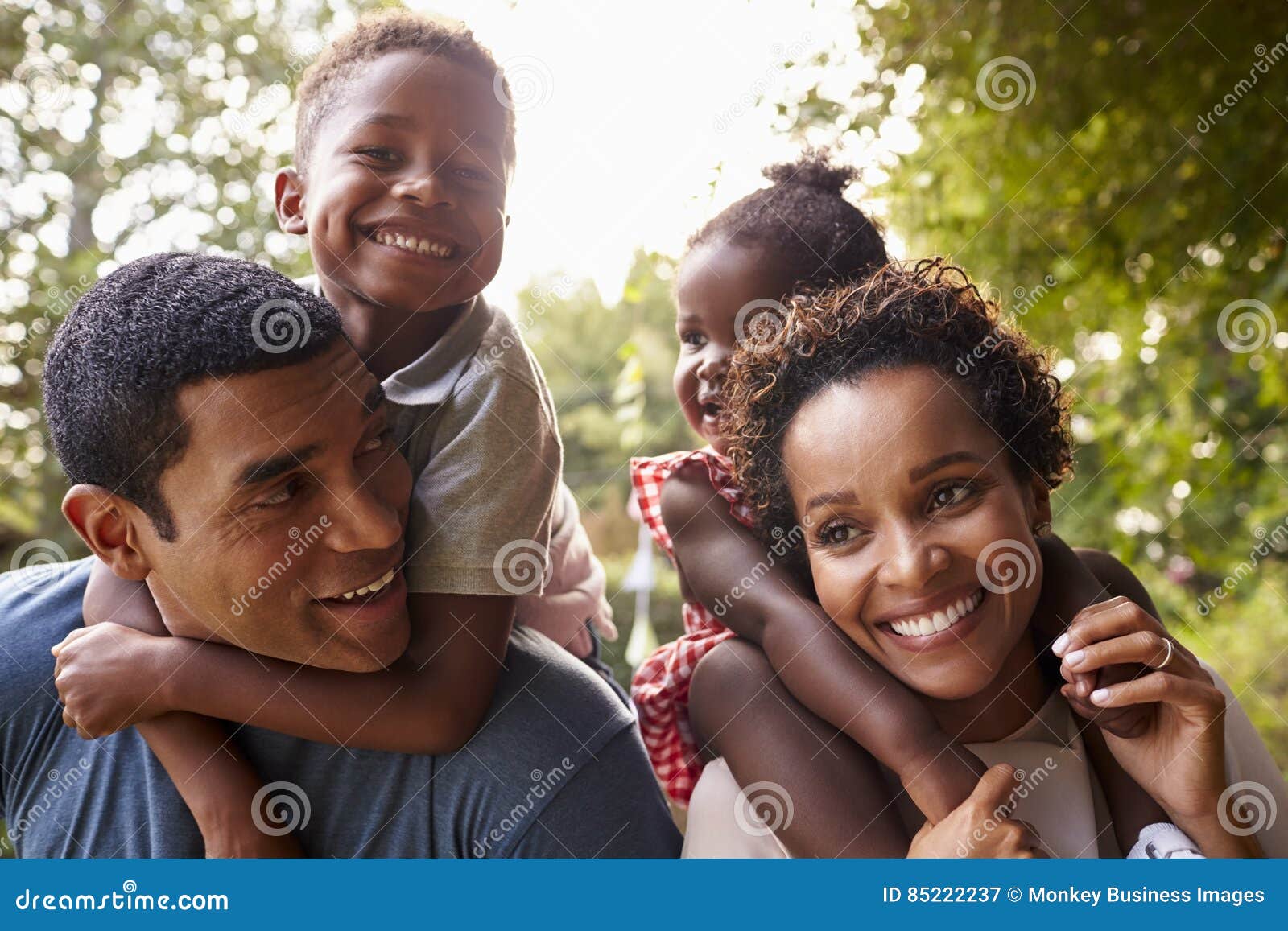 african american parents giving children piggyback rides