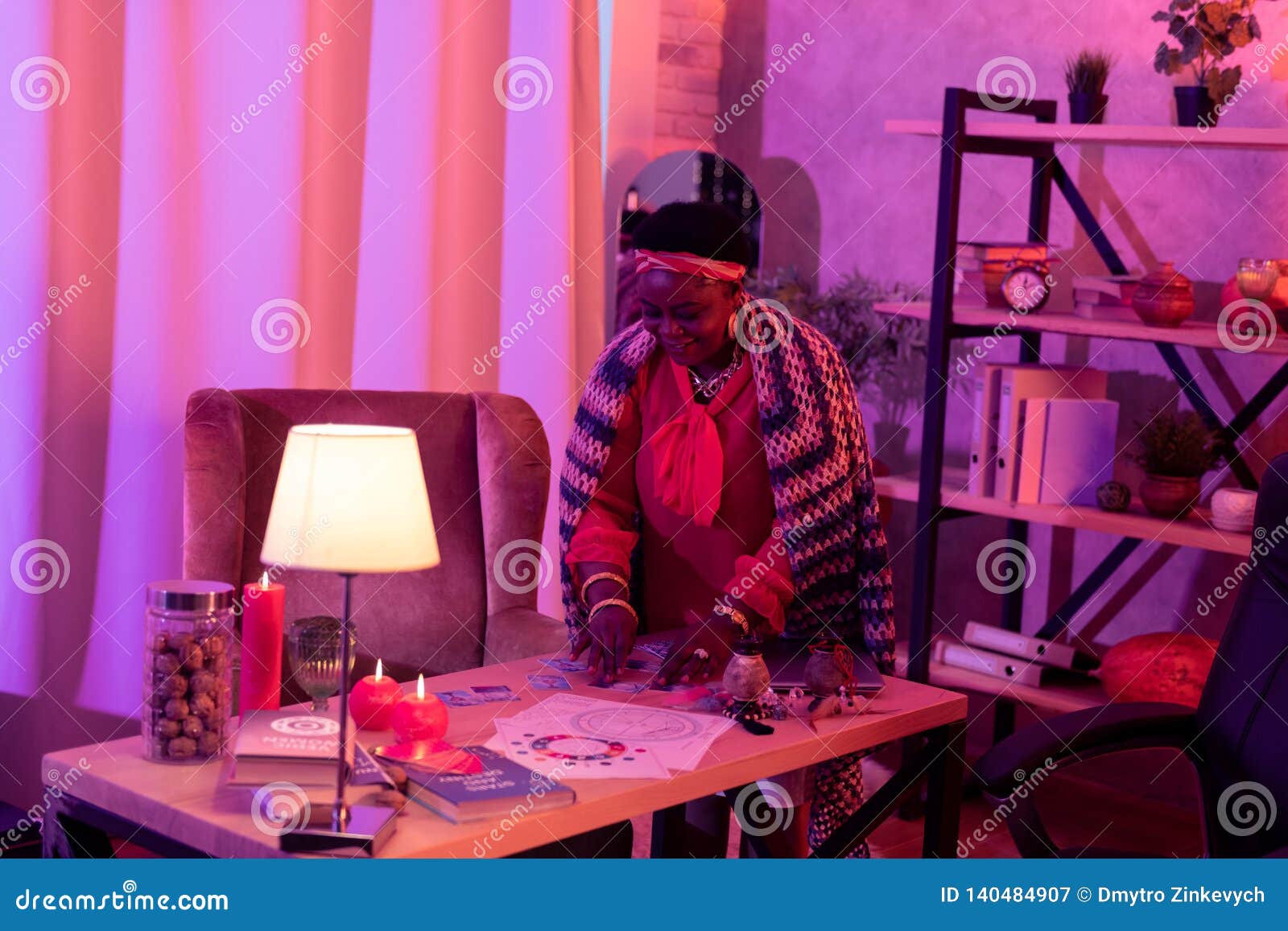 African American Plump Fortune-teller With Huge Earrings Standing Near The Table With Divination ...