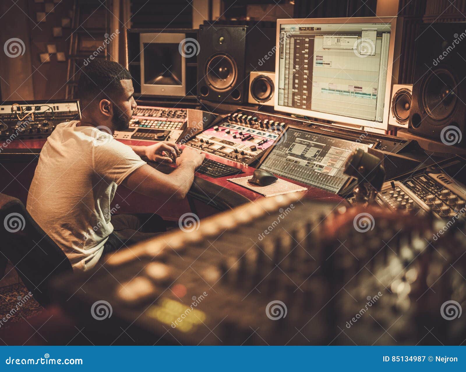 african american sound engineer working at mixing panel in boutique recording studio