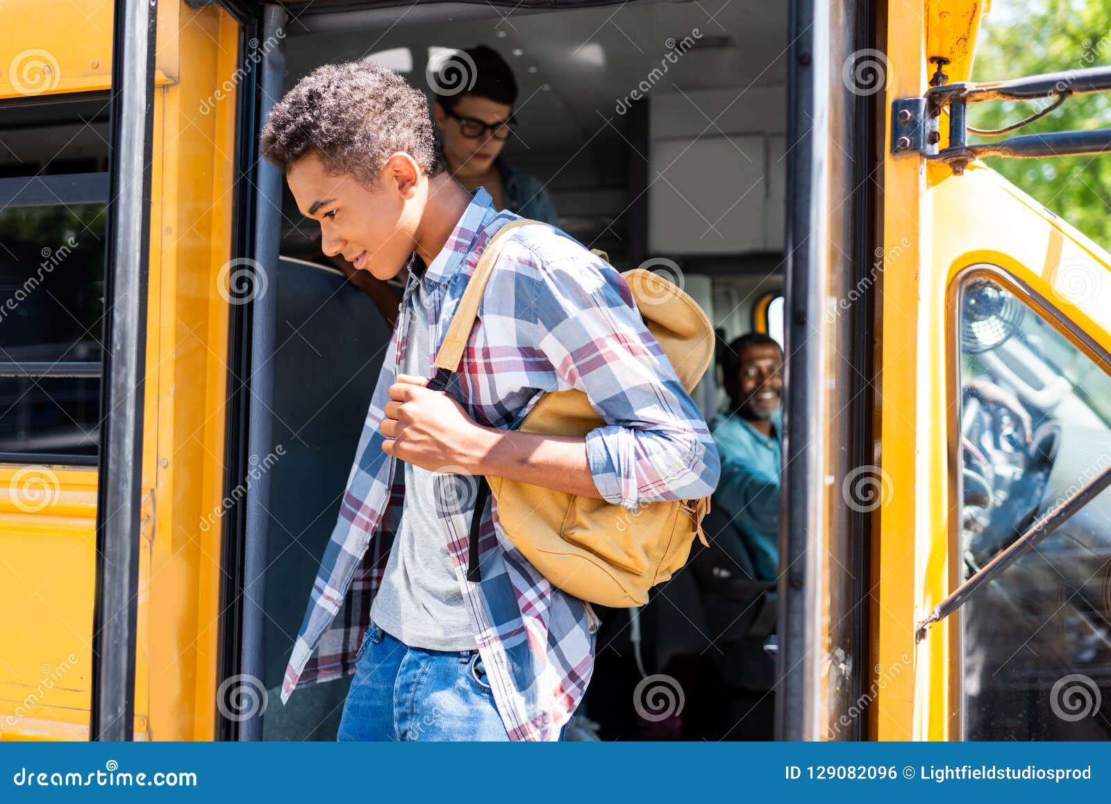 African American Student Walking Out of School Bus while Driver Looking