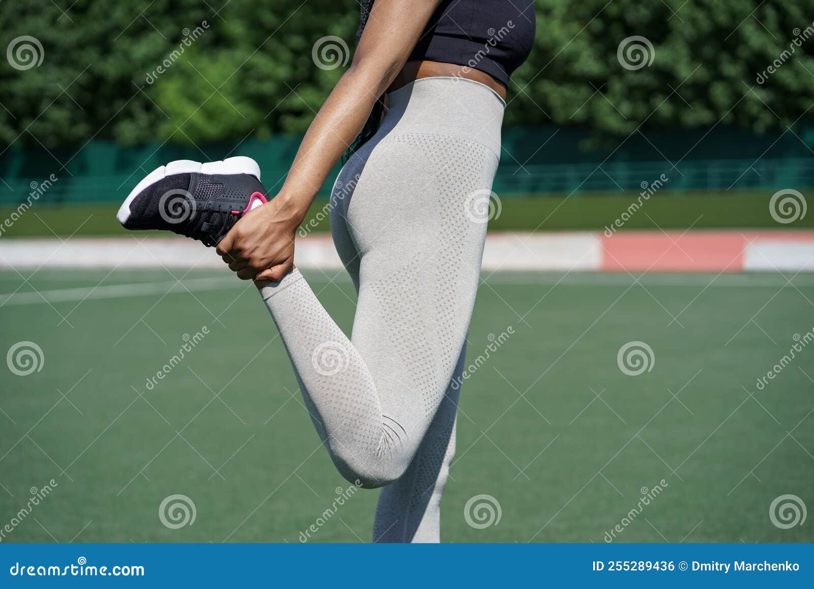 Black Woman in Sportswear Pumps Gluteal Muscles Holding Leg with Hand