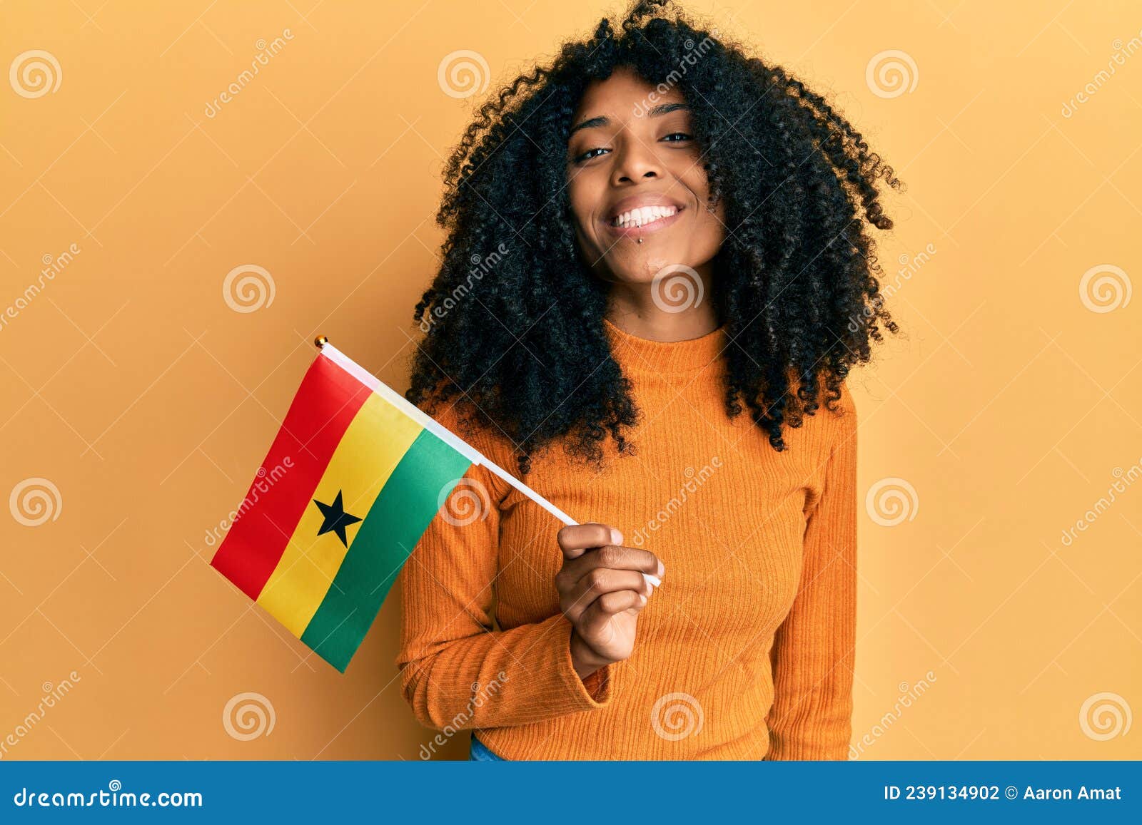 African American Woman with Afro Hair Holding Ghana Flag Looking ...