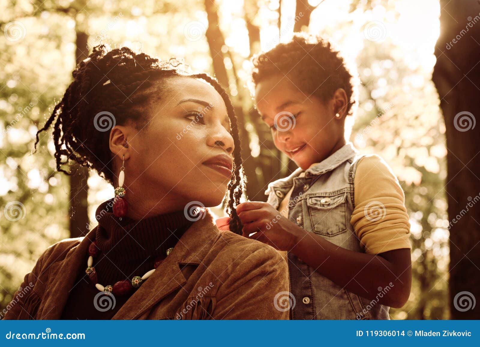 african american woman with daughter in park.