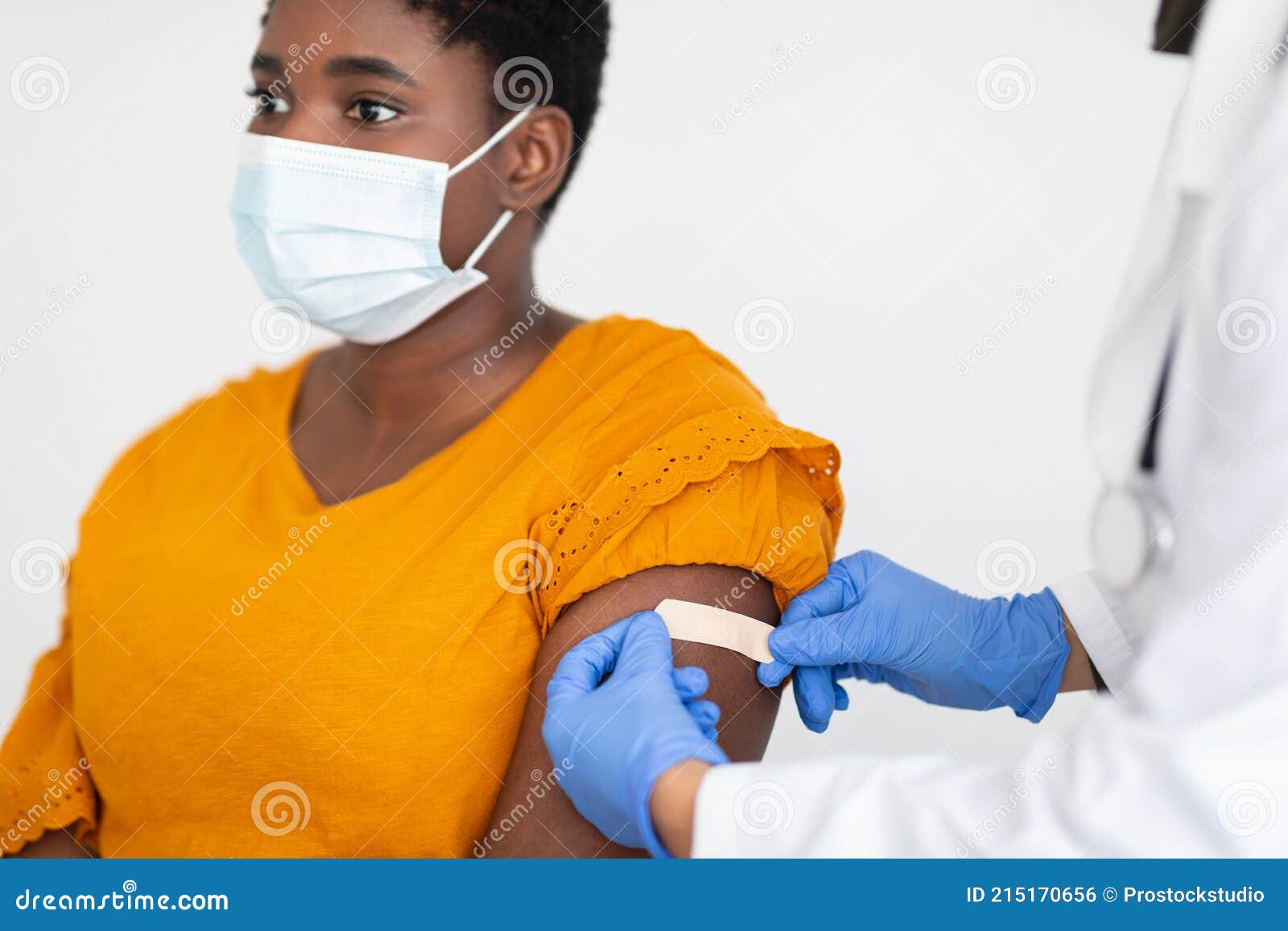 african american woman getting vaccinated against covid-19, white background, cropped