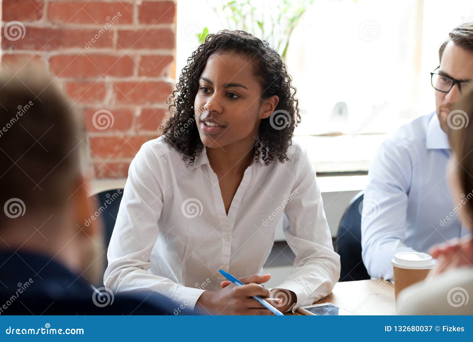 african american woman speaking at company meeting
