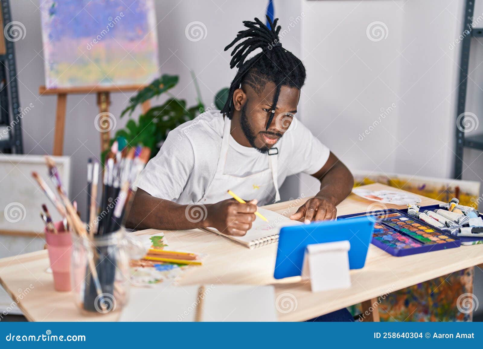 African American Woman Using Touchpad Drawing on Notebook at Art Studio