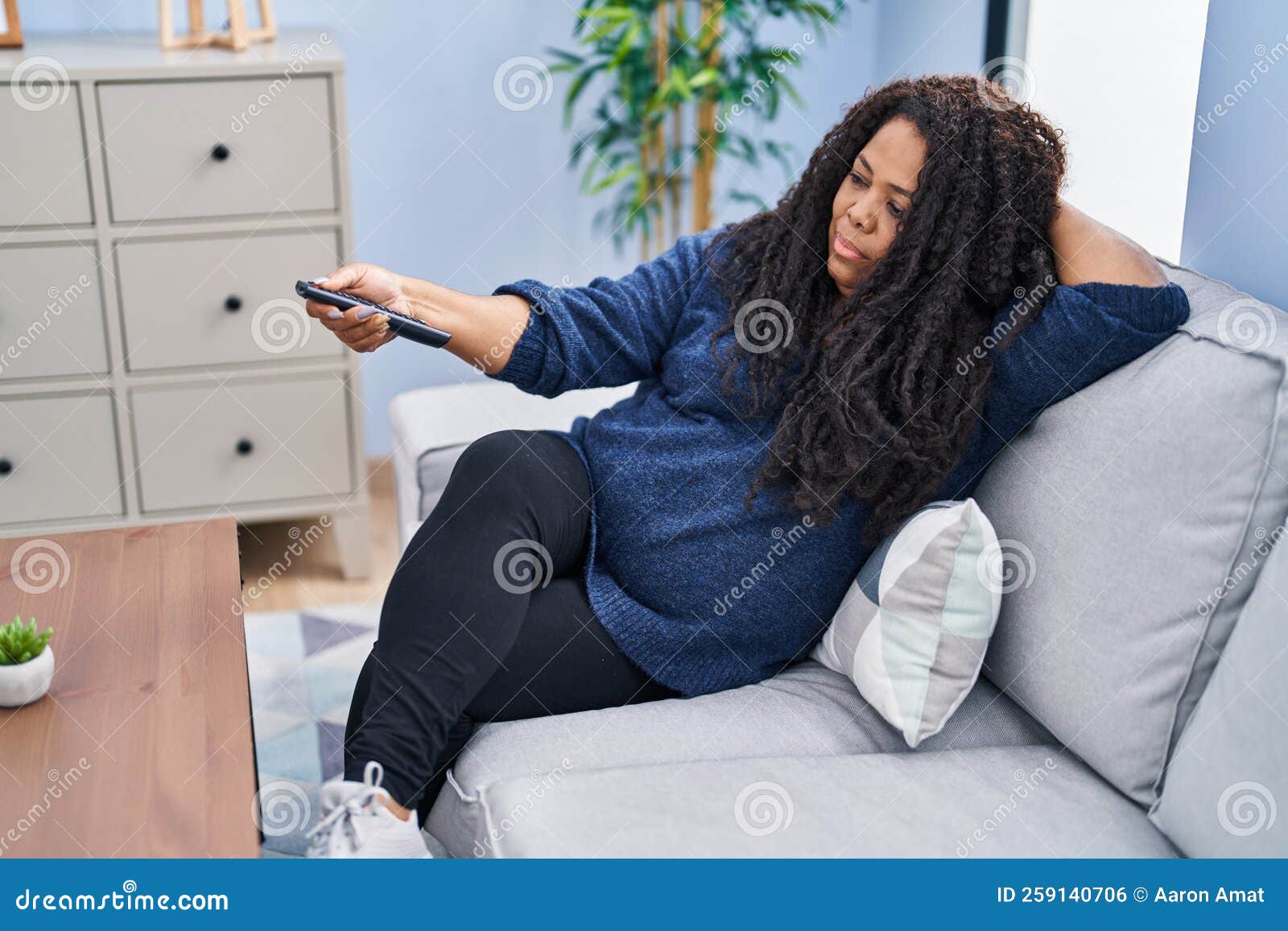 African American Woman Watching Tv Lying on Sofa with Boring Expression ...