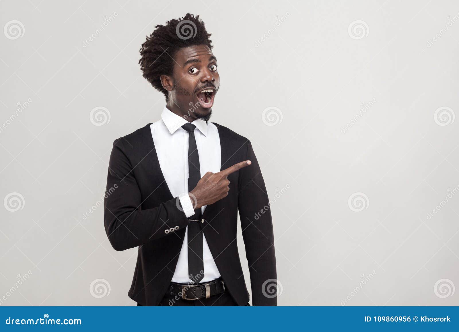 African Businessman Pointing Finger at Copy Space . Studio Shot, Gray ...